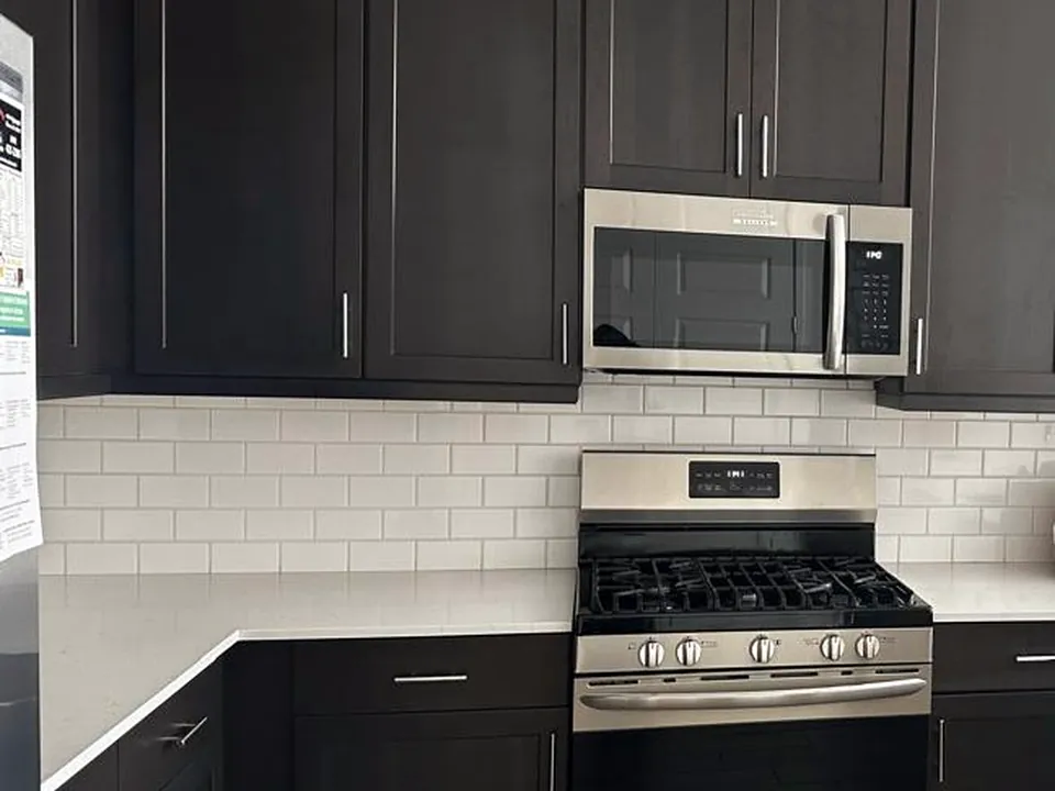 Bright kitchen with stainless steel appliances and white quartz countertops